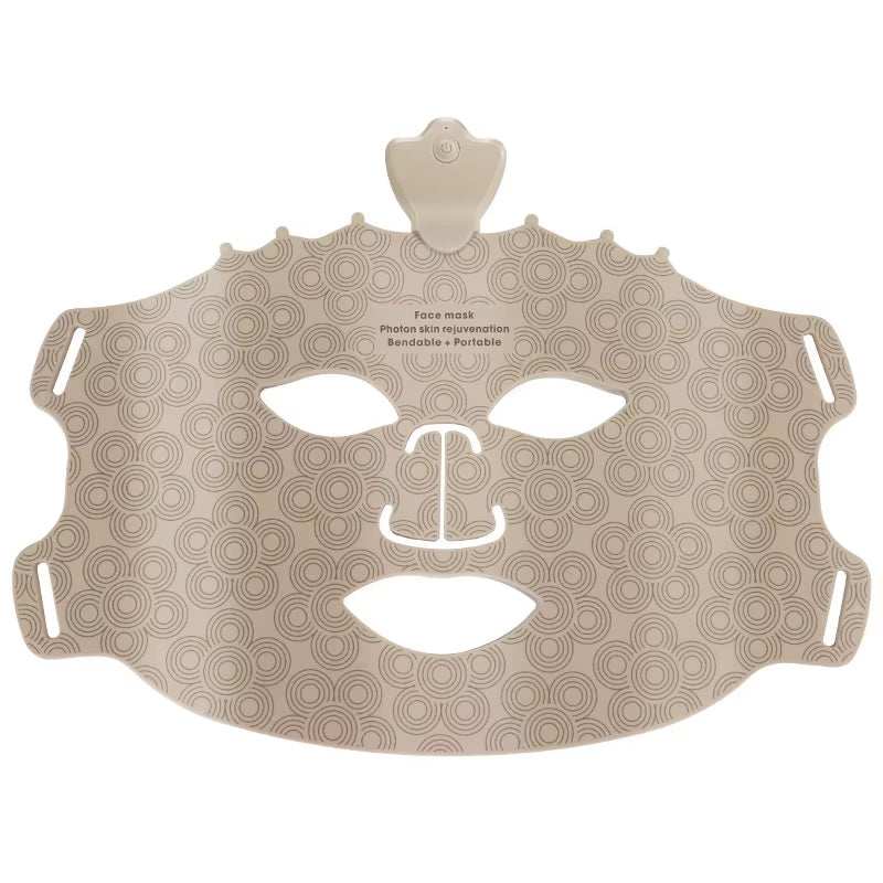 LED Photon Beauty Mask, beige silicone face mask with repeating circular pattern, eye and mouth cutouts, and ear loops