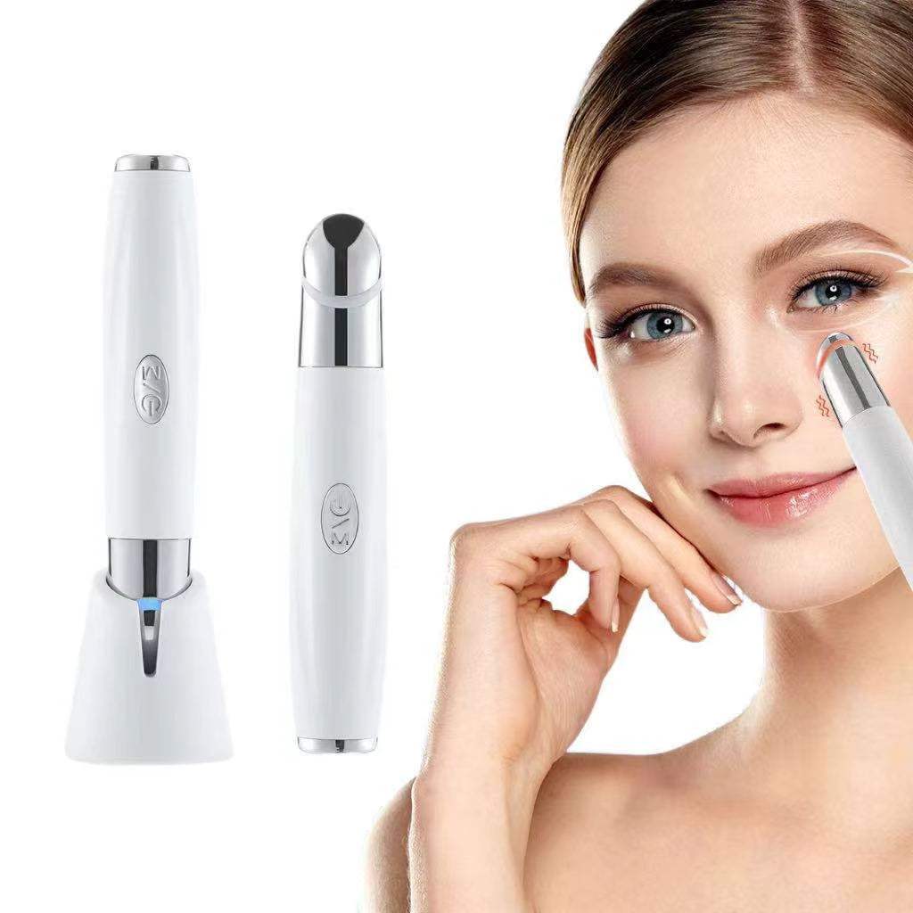 Eye Care Beauty Device, white handheld facial massager with metallic treatment tip and charging stand gestalt