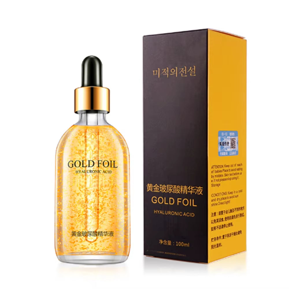 24K Gold Face Serum in a clear glass dropper bottle, featuring visible gold foil flakes and black-gold packaging