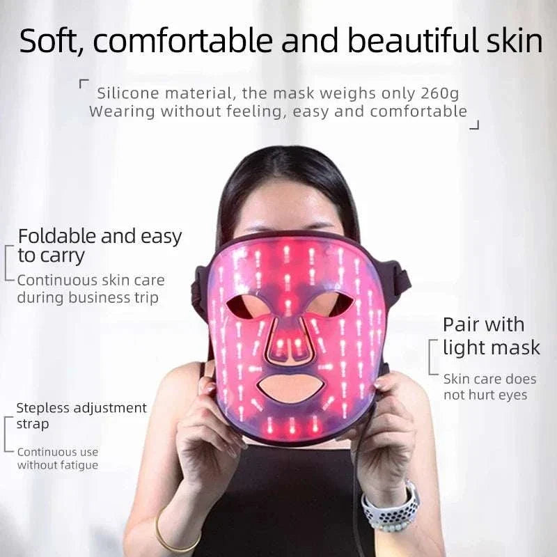 LED Face Mask with pink illuminated LED lights, silicone material, adjustable strap, held by a person