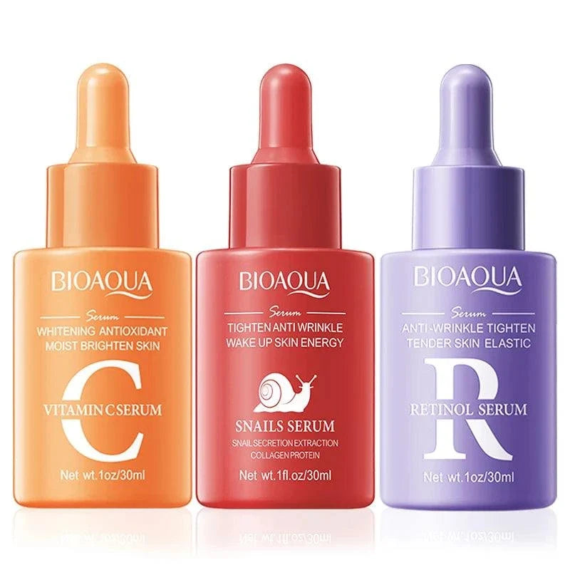 Facial Essence Serum in three colorful glass dropper bottles: orange vitamin C, red snail, and purple retinol formulas.