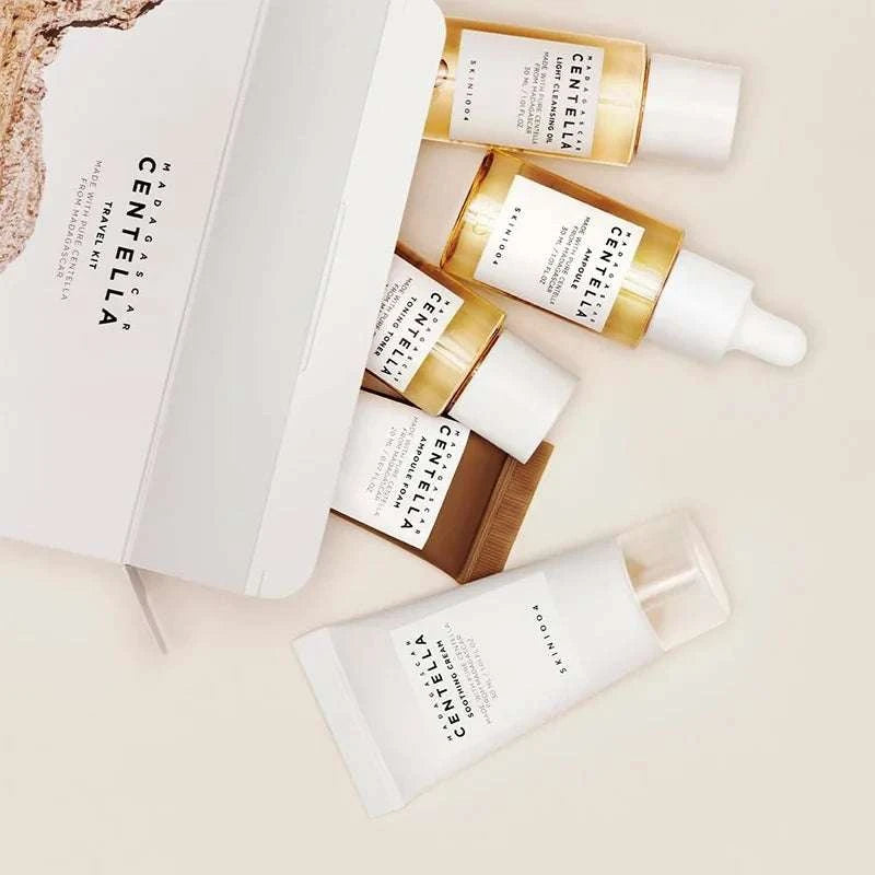 Centella Travel Skincare Kit with five white and amber travel-size skincare bottles in a box, including dropper ampoule and cream