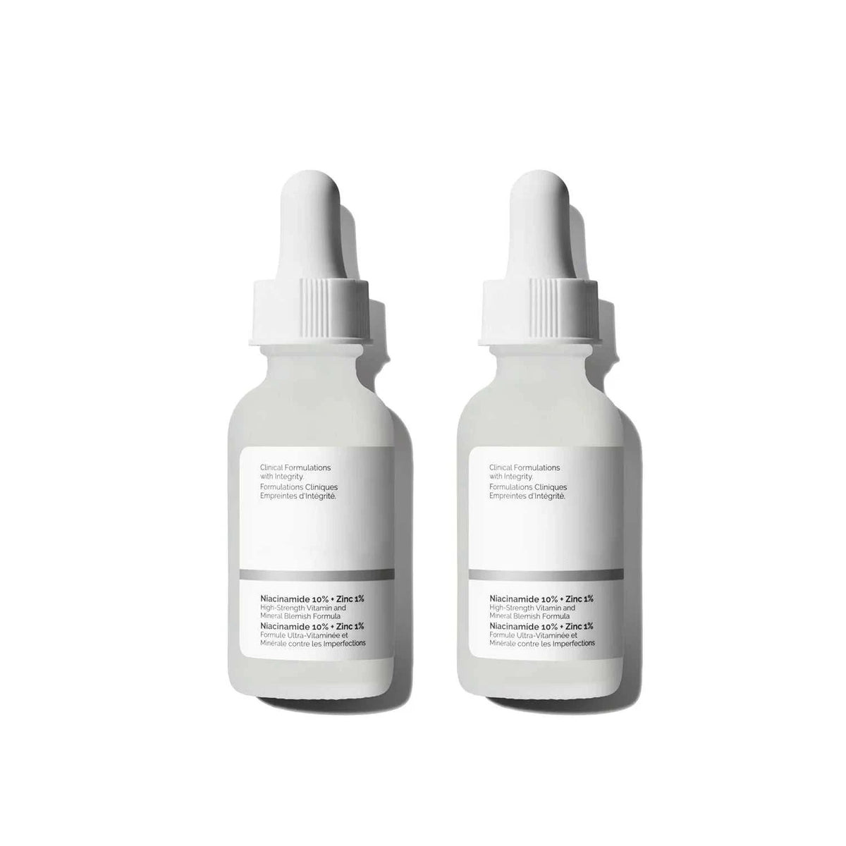 Niacinamide serum bottles, white glass with dropper caps and minimalist labels featuring 10% Niacinamide formulation