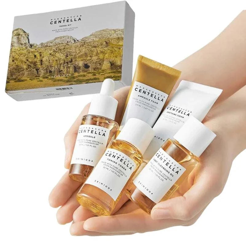 Centella Travel Skincare Kit with five clear bottles and tubes, white labels, and amber skincare formulas in a boxset