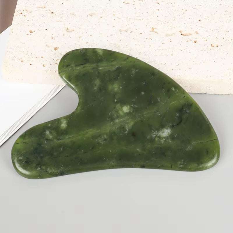 Jade Gua Sha Massager in dark green mottled stone, featuring a smooth heart-shaped design for facial massage