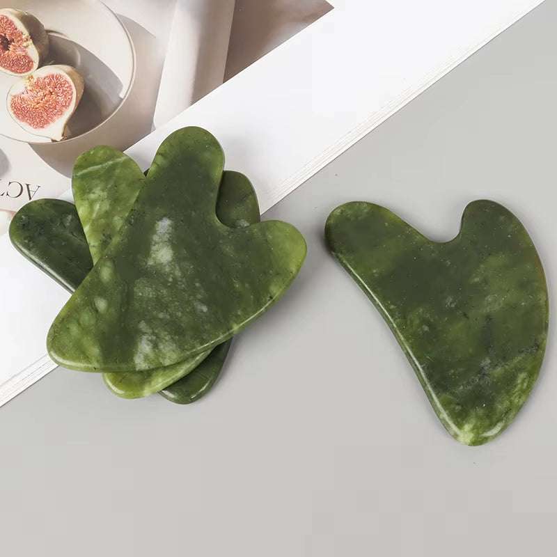 Jade Gua Sha Massager set in dark green stone, featuring heart-shaped and curved facial massage tools