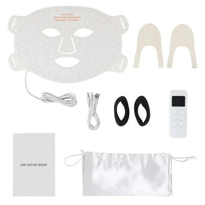 Home Use Therapy Face Device consisting of a white flexible silicone LED facial mask with geometric pattern, control remote, cables, black eye pads, beige nose grips, instruction booklet, and white drawstring pouch