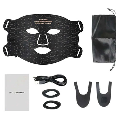 Black silicone LED facial mask with geometric patterns, adjustable straps, a USB cable, two black attachments, a pouch, and an instruction manual for Red Light Photon Therapy
